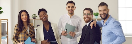 Unity, motivation and teamwork. Funny creative business team, diverse company representatives, interracial coworkers with paper documents standing together and laughing posing for office portrait