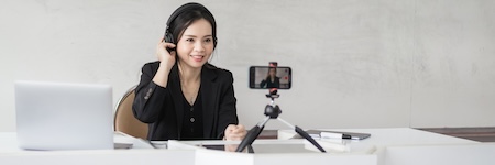 Stock photo of a Southeast Asian Ethnic business woman student teacher tutor video conference calling on laptop computer talk by webcam learn teach in online chat, distance webinar online teaching concept